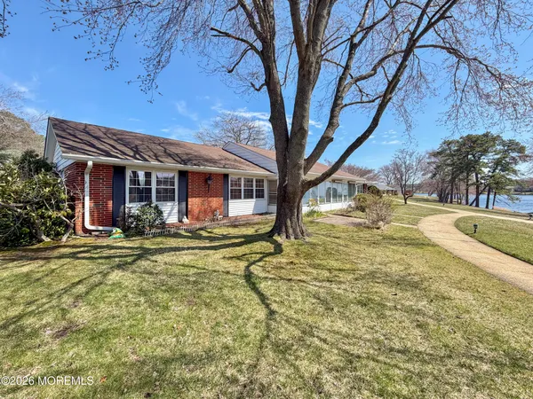 a view of a house with backyard and tree