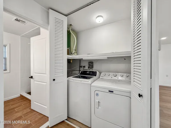 a view of washer and dryer with wooden cabinets