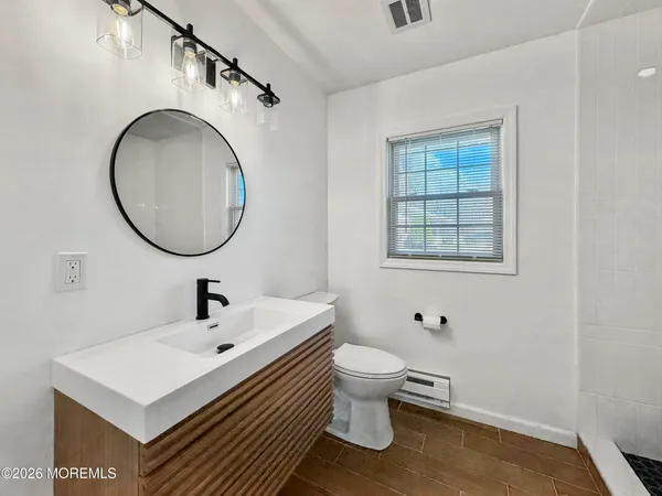 a bathroom with a toilet sink and mirror