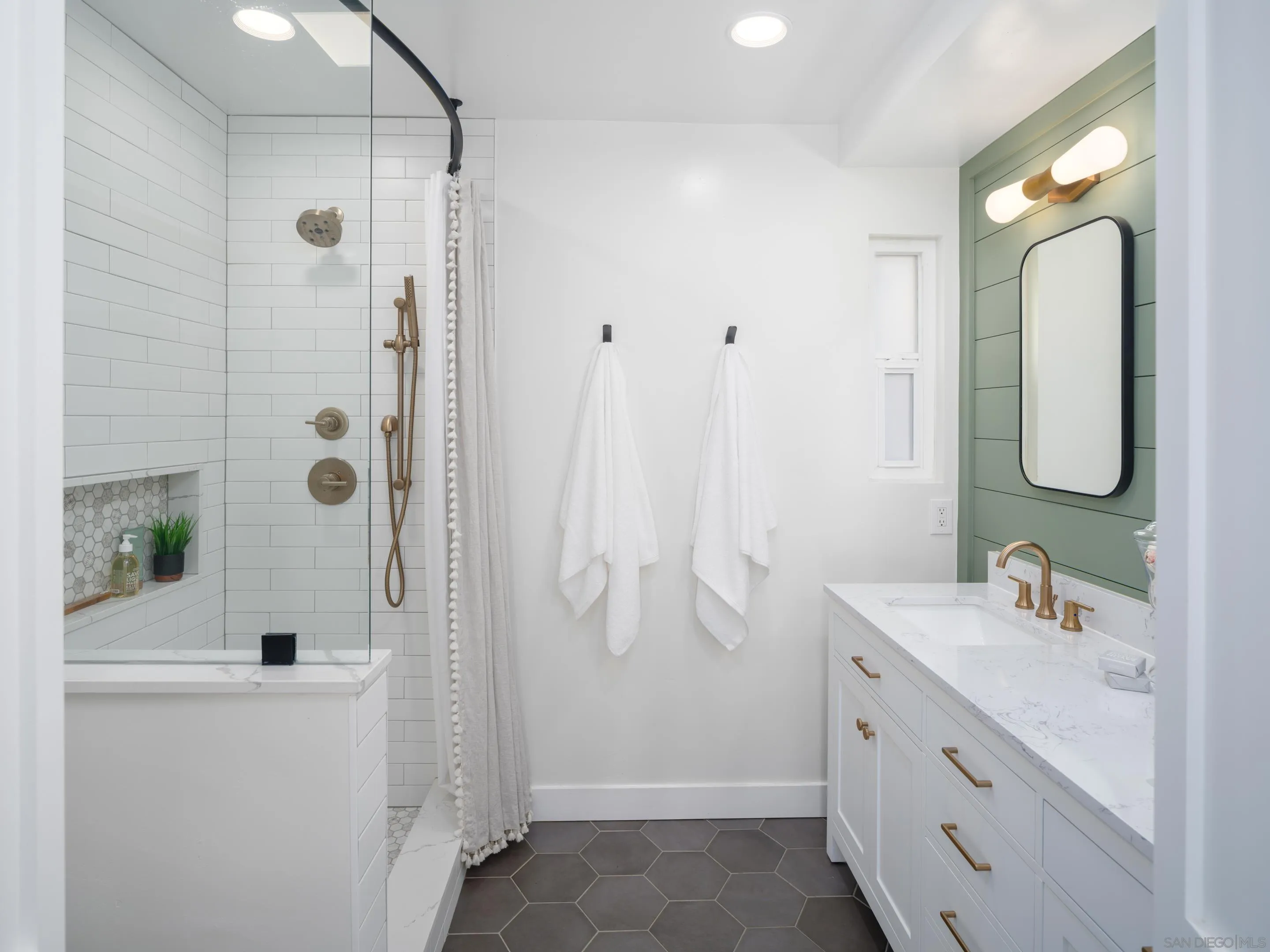 7053 Snapdragon Drive Carlsbad, CA 92011 - Photo 15 of 35 a bathroom with a double vanity sink a mirror a shower and a bathtub