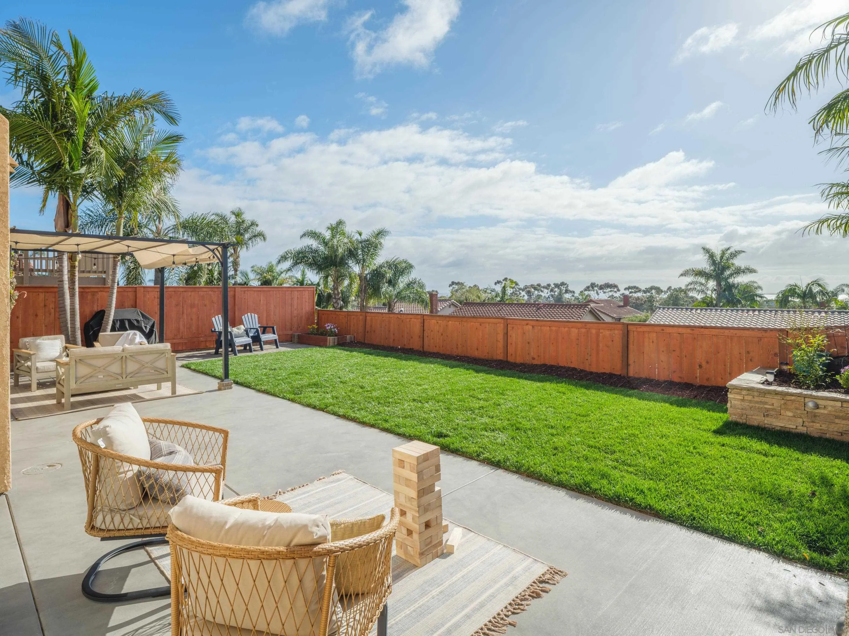 7053 Snapdragon Drive Carlsbad, CA 92011 - Photo 27 of 35 a patio with table and chairs and couches with wooden fence