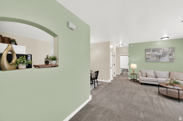 8215 Clear Rock Road, Unit 12 Eagle Mountain, UT 84005 - Photo 4 of 38 Open concept living area featuring light green and neutral wall tones, gray carpeting, a pass-through arched opening, and recessed ceiling lights
