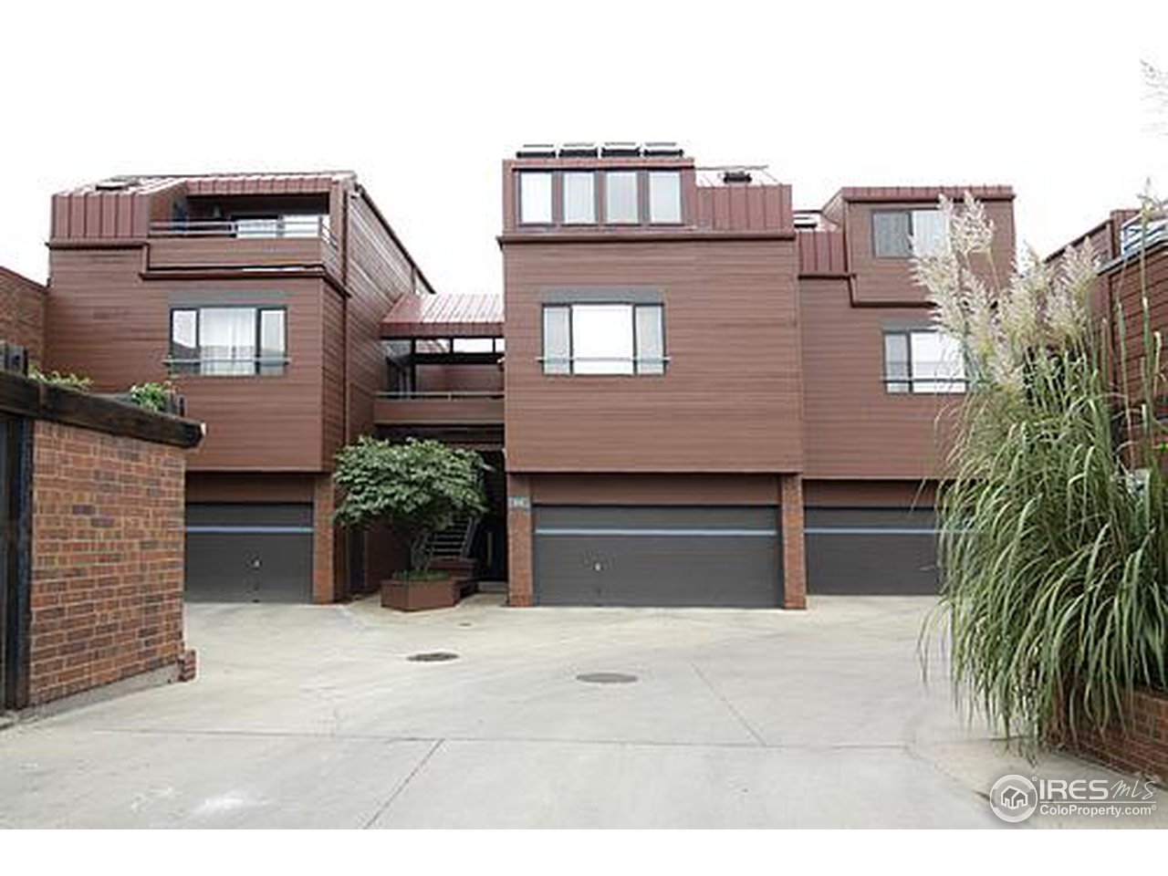 a view of a house with a yard and potted plants