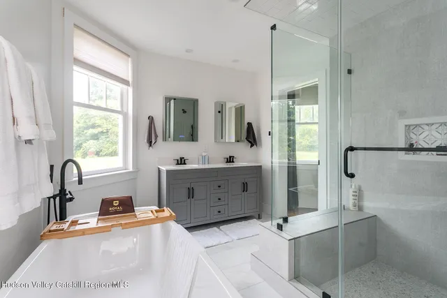 a bathroom with a tub sink and mirror