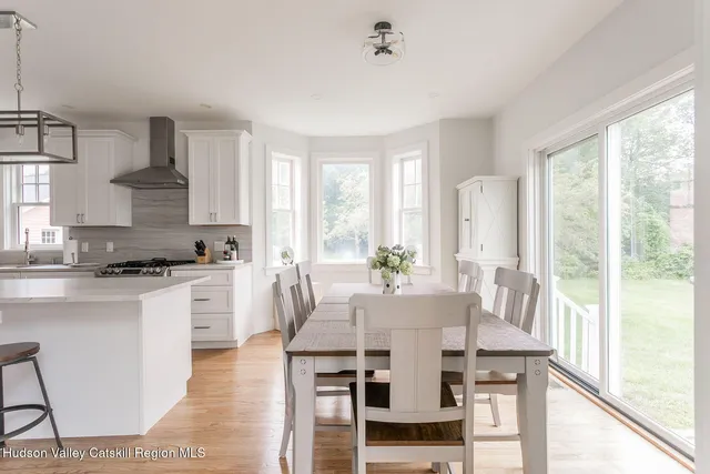 a kitchen with granite countertop a stove a sink a dining table and chairs