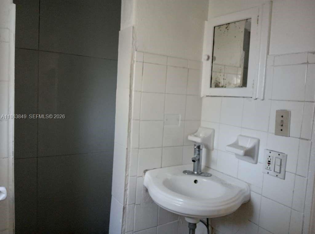 1925 Northwest 56th Street Miami, FL 33142 - Photo 11 of 27 a bathroom with a sink and a mirror