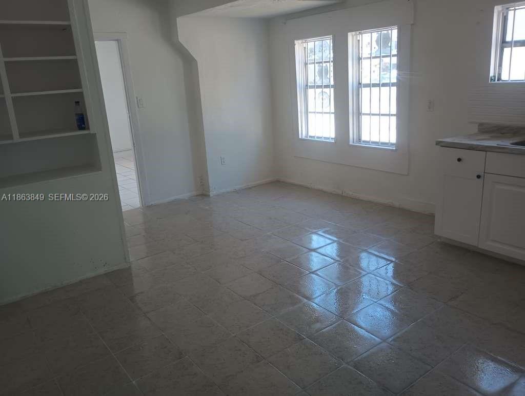 1925 Northwest 56th Street Miami, FL 33142 - Photo 26 of 27 an empty room with windows and way to kitchen