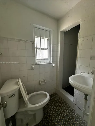 a white toilet sitting next to a bathroom sink