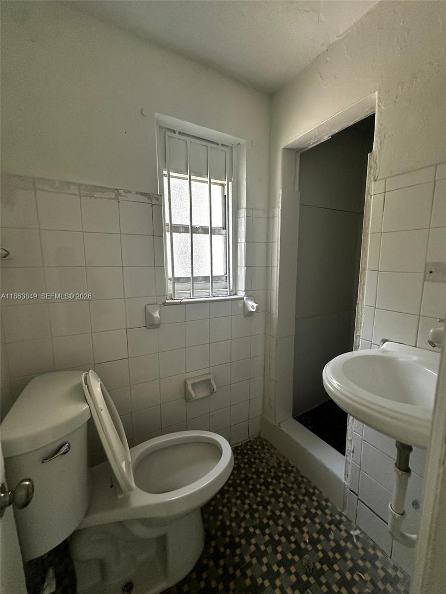 1925 Northwest 56th Street Miami, FL 33142 - Photo 8 of 27 a white toilet sitting next to a bathroom sink