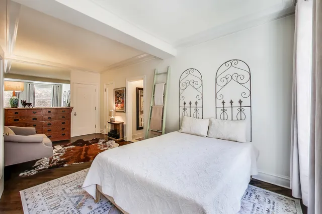 a spacious bedroom with a bed a couch and a dresser