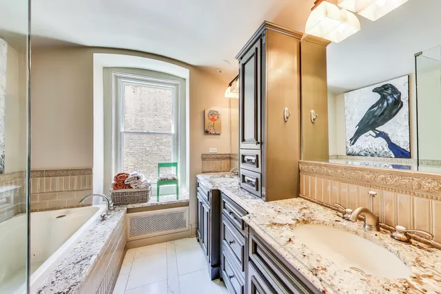 a spacious bathroom with a tub sink and mirror