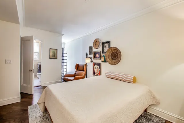 a bedroom with a bed and painting on the wall