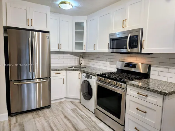 a kitchen with appliances a microwave and cabinets
