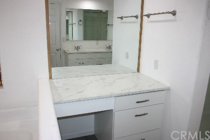 1350 Cabrillo Drive Hemet, CA 92543 - Photo 17 of 30 a bathroom with a granite countertop sink and white cabinets