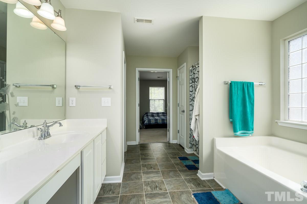 3612 Weir Way Raleigh, NC 27616 - Photo 12 of 19 a bathroom with a bathtub a sink and a large mirror