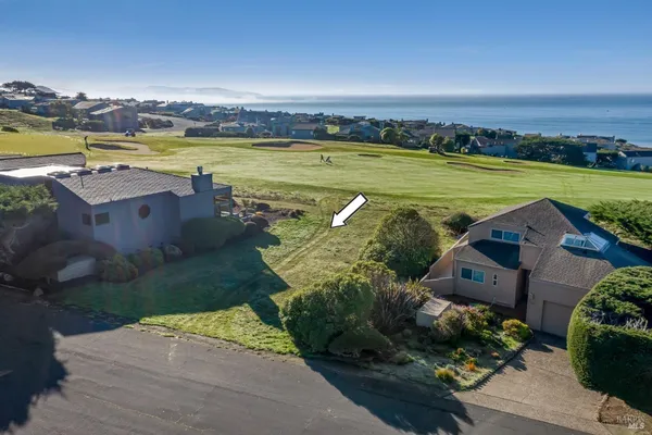 an aerial view of a house with a garden and lake view