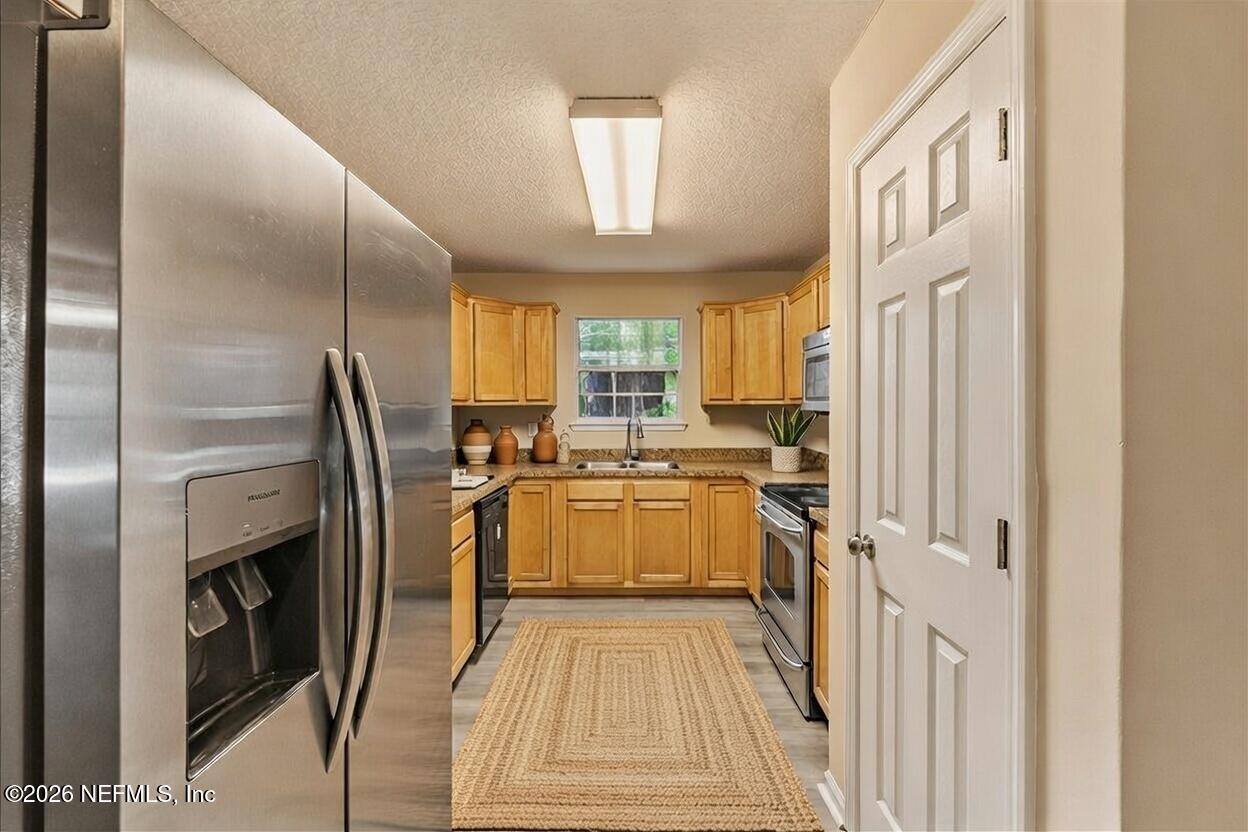 4527 Clairmont Road Jacksonville, FL 32207 - Photo 11 of 40 a kitchen with a refrigerator a sink and a stove