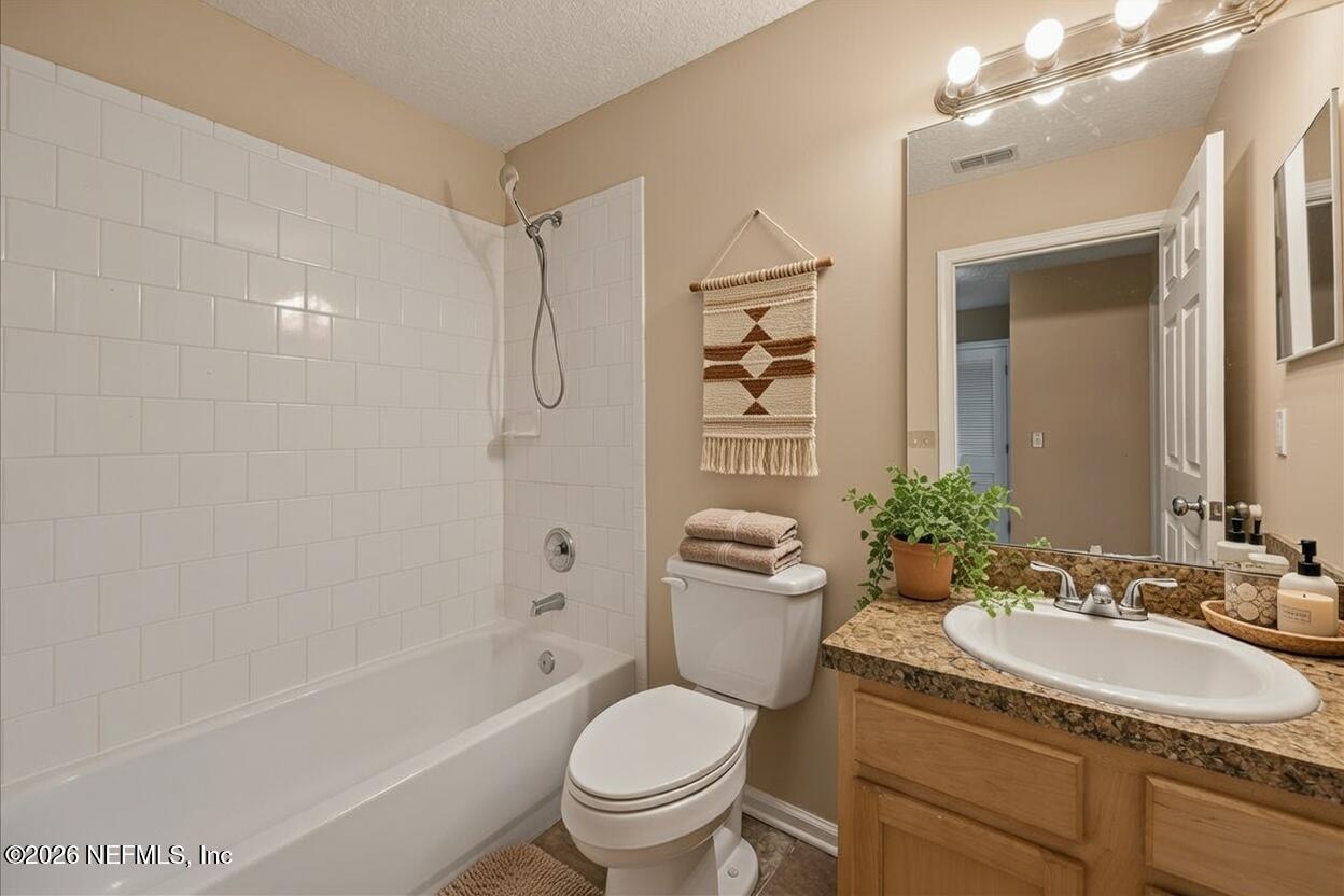 4527 Clairmont Road Jacksonville, FL 32207 - Photo 33 of 40 a bathroom with a granite countertop toilet a sink and a bathtub