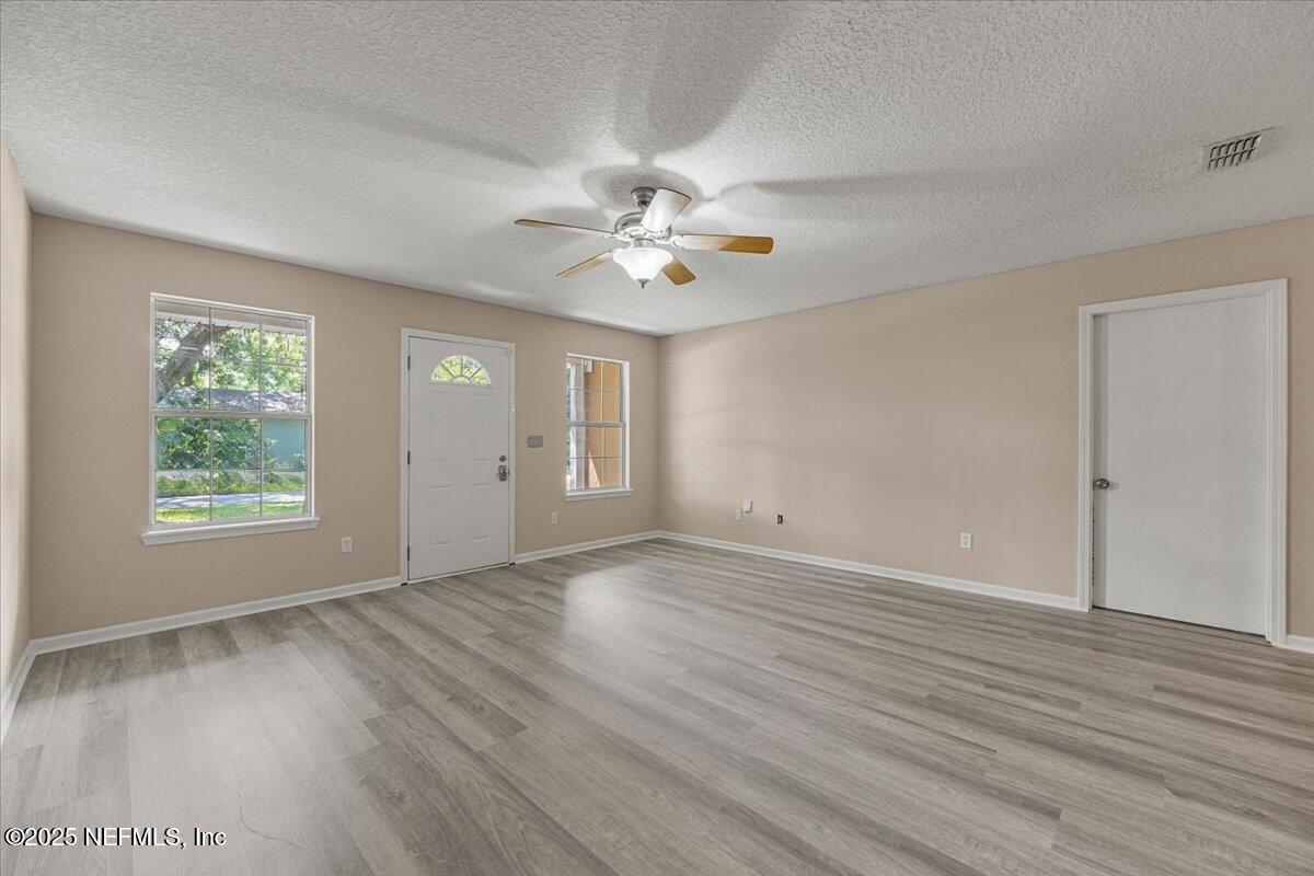 4527 Clairmont Road Jacksonville, FL 32207 - Photo 9 of 40 an empty room with wooden floor and windows