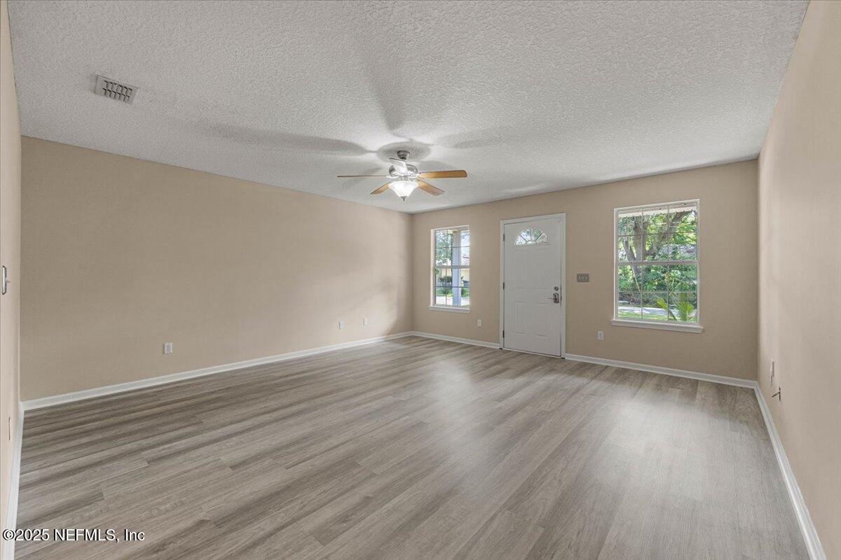 4527 Clairmont Road Jacksonville, FL 32207 - Photo 10 of 40 an empty room with wooden floor and windows