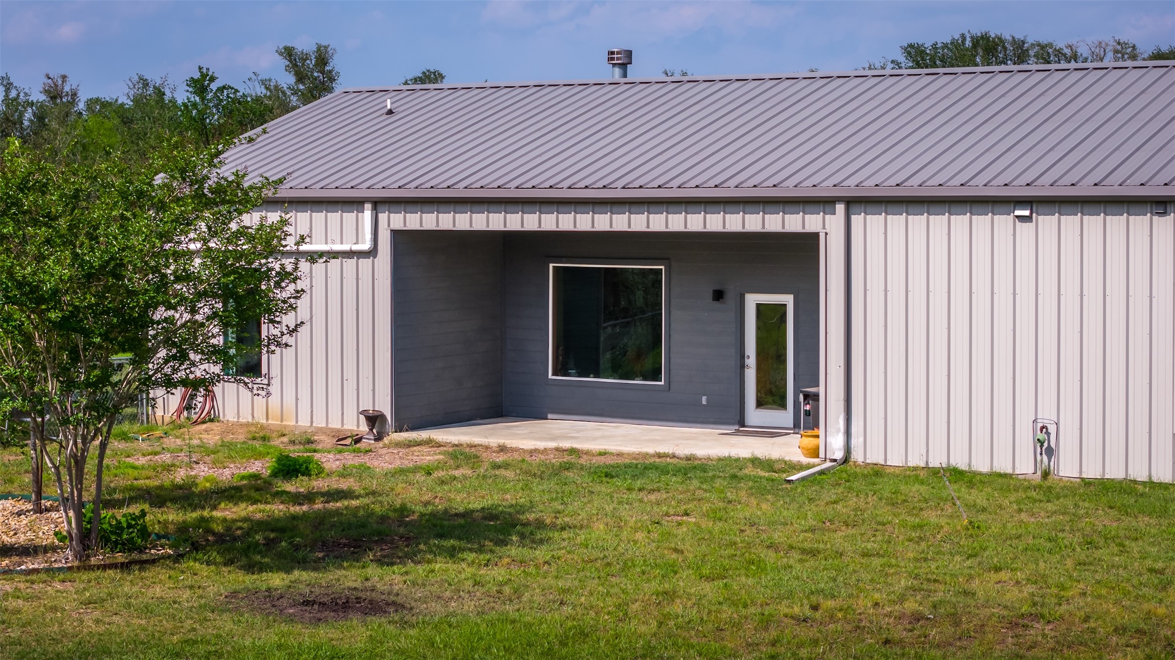4082 Old Colony Line Road Lockhart, TX 78644 - Photo 40 of 40 Metal-sided home offers a modern aesthetic with a concrete patio for outdoor enjoyment.