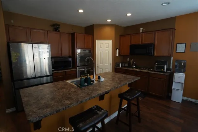 a kitchen with granite countertop a refrigerator and a sink