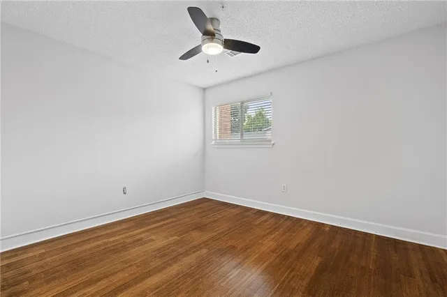 a view of a room with wooden floor and ceiling fan