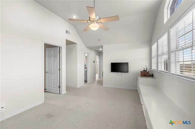 a view of an empty room with a fireplace and a window