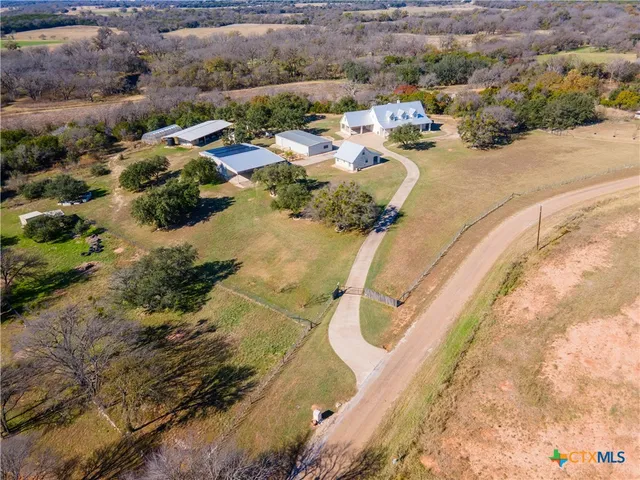 an aerial view of a house with a yard and lake