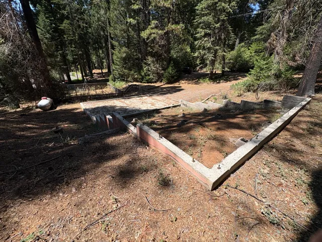 a view of a yard with wooden fence