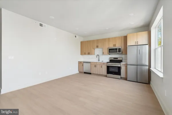 a kitchen with cabinets stainless steel appliances and a counter space