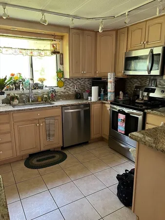 a kitchen with stainless steel appliances granite countertop a stove a sink and a microwave