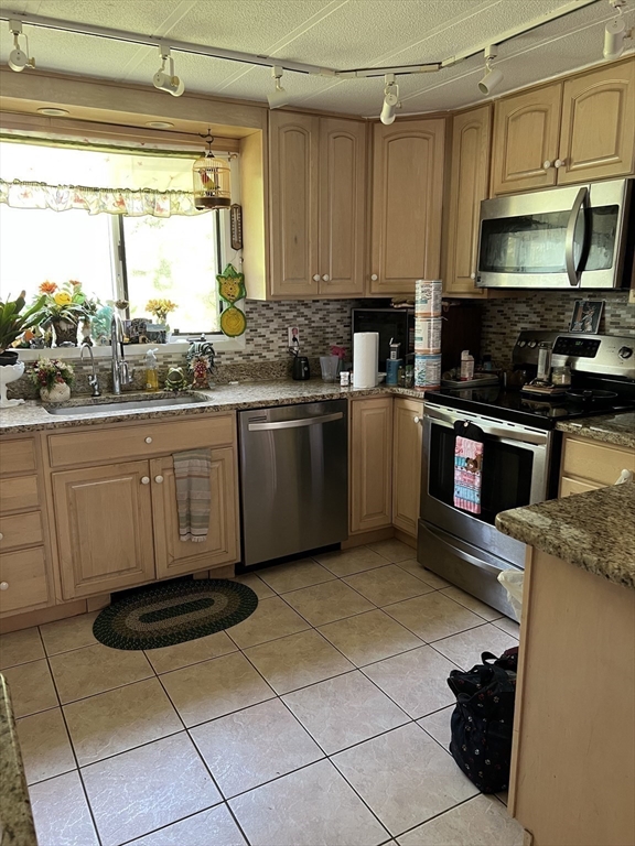 53 Wagon Hill Road Marlborough, MA 01752 - Photo 11 of 32 a kitchen with stainless steel appliances granite countertop a stove a sink and a microwave