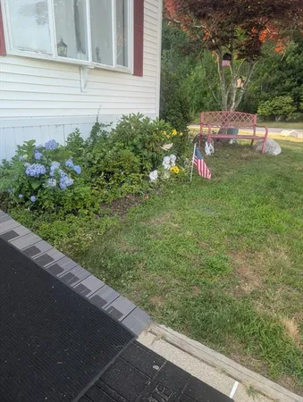 a view of a backyard with brick wall and potted plants