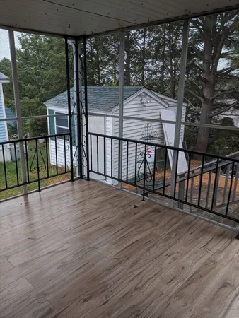 a view of a balcony with wooden floor and iron fence