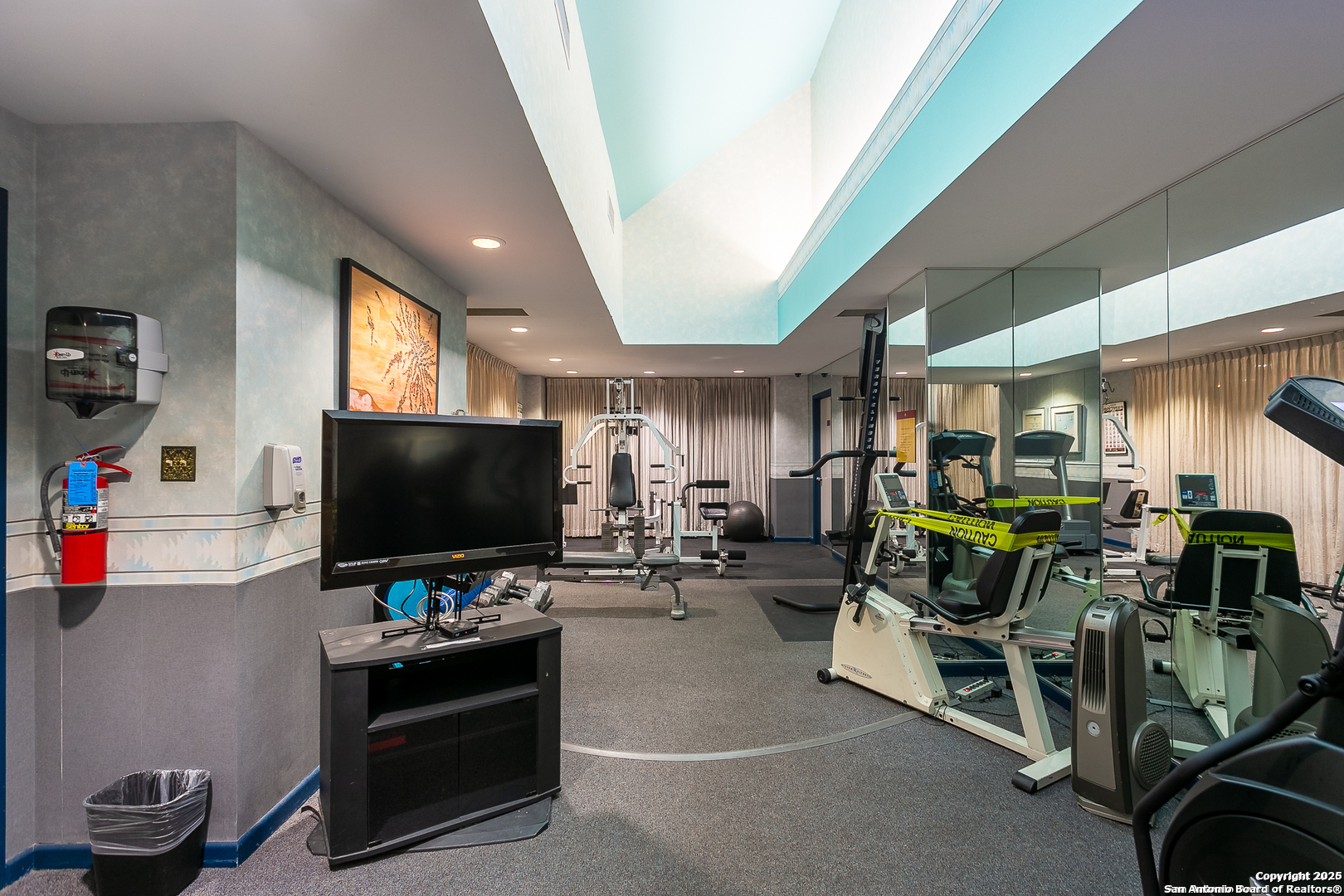 7701 Wurzbach Road, Unit 301 San Antonio, TX 78229 - Photo 17 of 42 a room with gym equipment and a flat screen tv