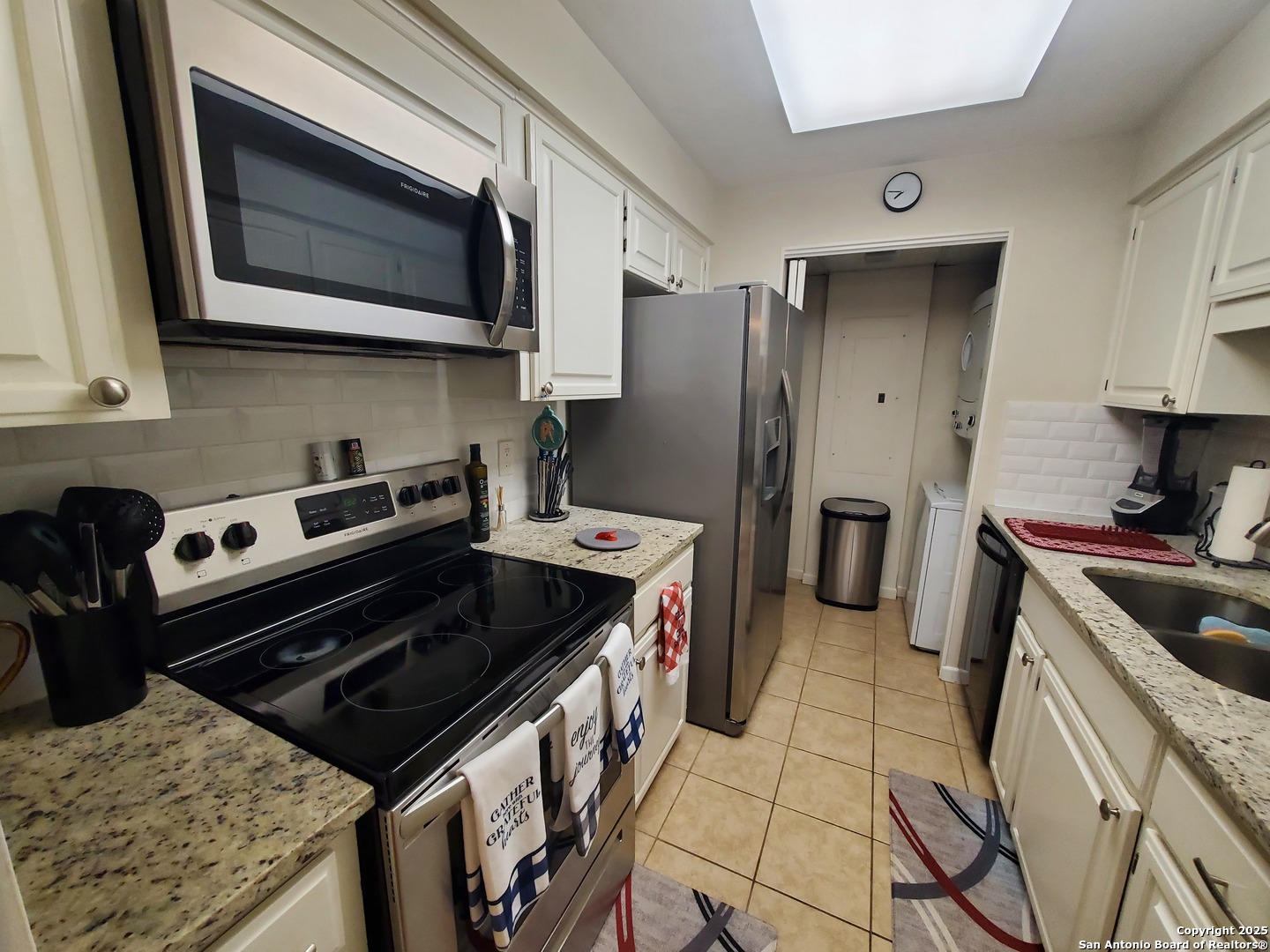 7701 Wurzbach Road, Unit 301 San Antonio, TX 78229 - Photo 25 of 42 a kitchen with stainless steel appliances granite countertop a stove microwave and refrigerator