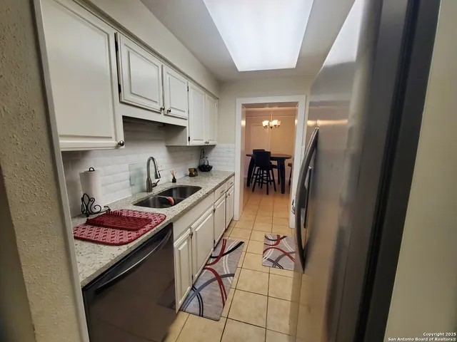 a kitchen with stainless steel appliances granite countertop a sink stove and cabinets