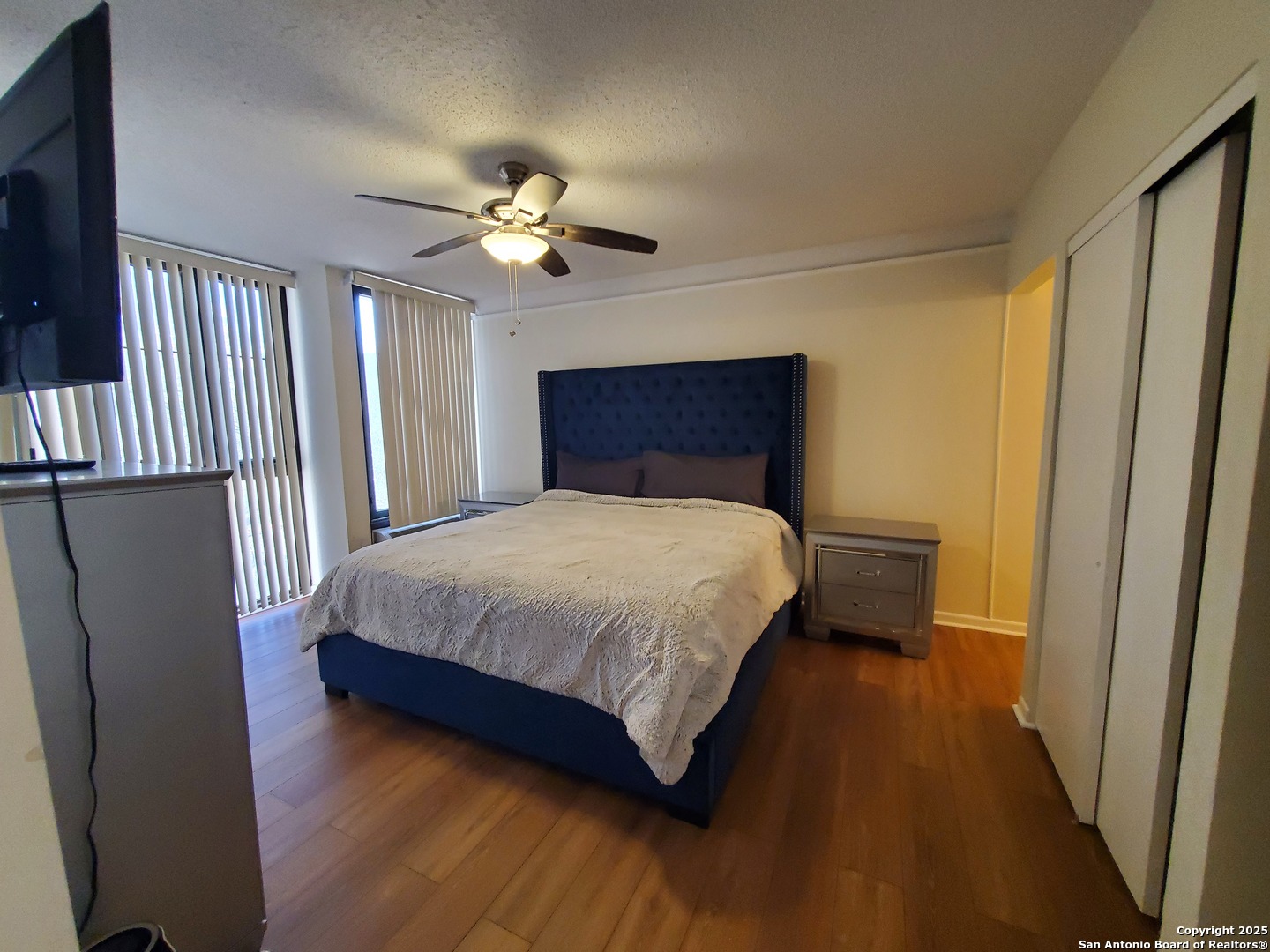 7701 Wurzbach Road, Unit 301 San Antonio, TX 78229 - Photo 32 of 42 a bedroom with a large bed and a chandelier