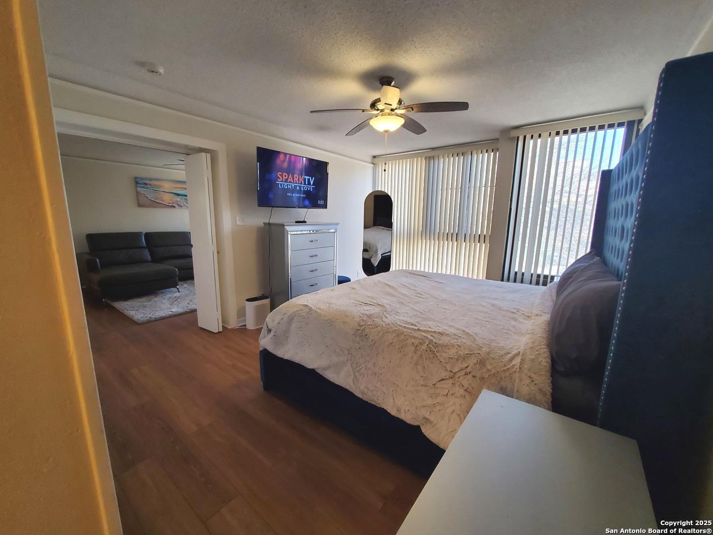 7701 Wurzbach Road, Unit 301 San Antonio, TX 78229 - Photo 34 of 42 a spacious bedroom with a bed and a chandelier