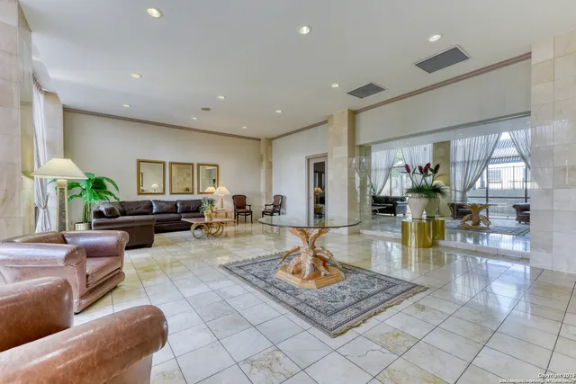 a living room with furniture a table and kitchen view