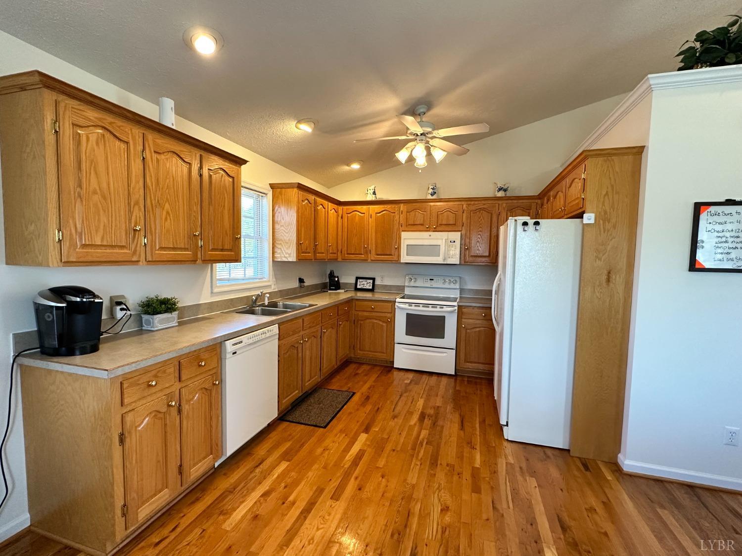137 Rhonda Road Rustburg, VA 24588 - Photo 13 of 50 a kitchen with wooden floors stainless steel appliances and white cabinets