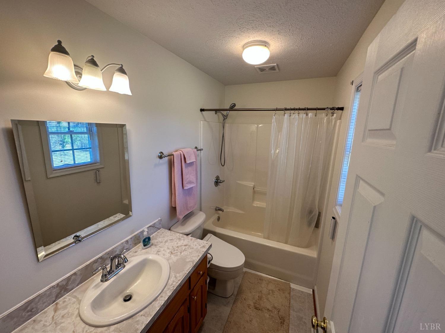 137 Rhonda Road Rustburg, VA 24588 - Photo 26 of 50 a bathroom with a granite countertop sink toilet a mirror a shower and a tub