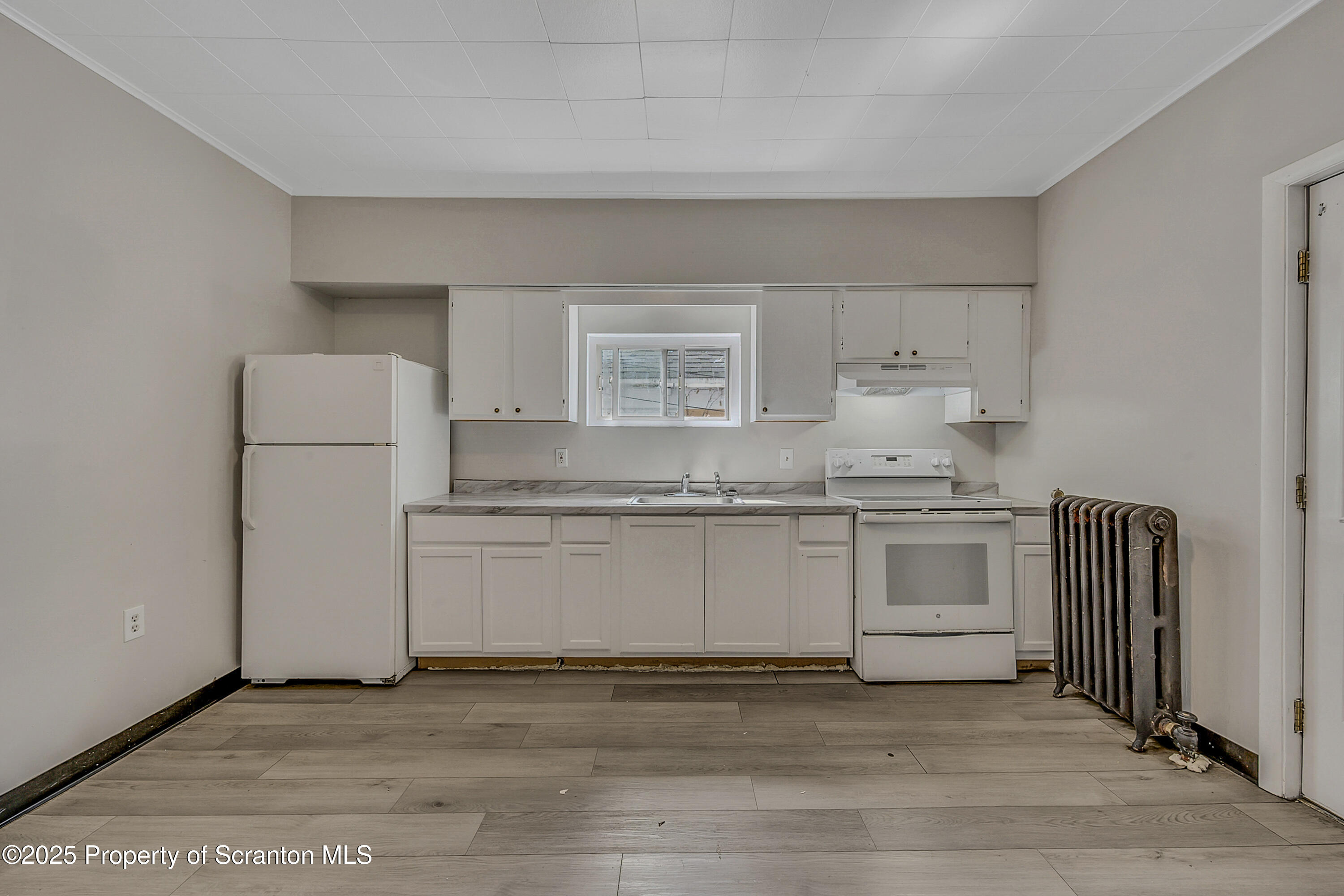 514 Stipp Court Scranton, PA 18510 - Photo 6 of 23 a kitchen with granite countertop white cabinets and white appliances