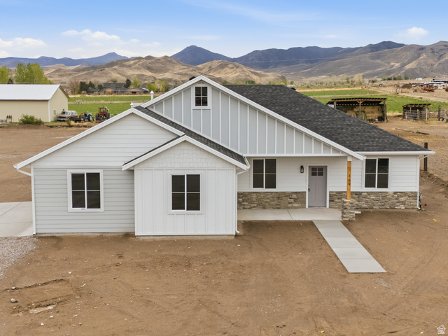 View of front facade featuring board and batten siding, a porch, a mountain view, and stone siding