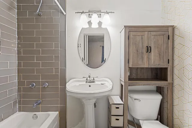a bathroom with a sink a toilet and shower