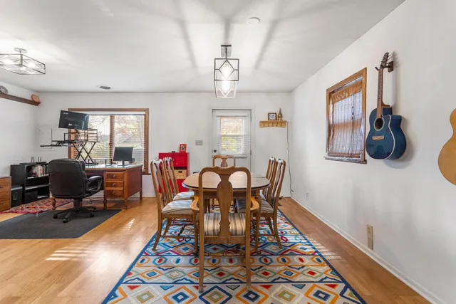 a view of a dining room with furniture a chandelier and wooden floor