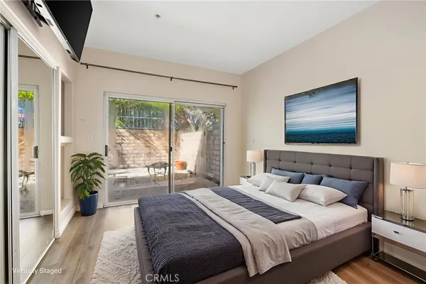 a bedroom with a balcony a bed and a flat screen tv