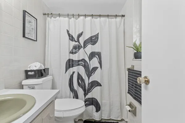 a bathroom with a granite countertop sink and a toilet