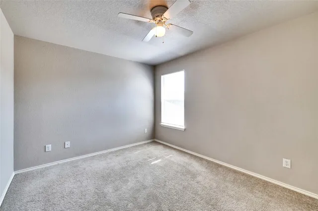 a view of an empty room with a ceiling fan